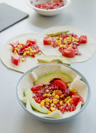 Mexican taco with vegetarian fillings on light table, cooking processの写真素材