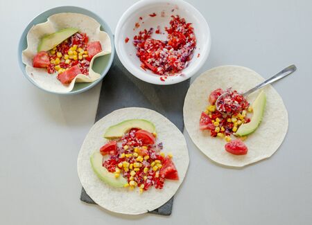 Mexican taco with vegetarian fillings on light table, cooking processの写真素材