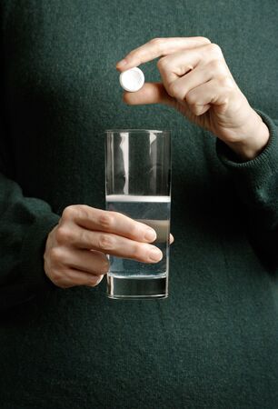 Woman holding tablet and glass of waterの写真素材