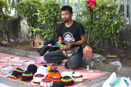 BANGKOK THAILAND - OCTOBER 27 : An unidentified man selling crochet hat on October 27,2011 at Tha...