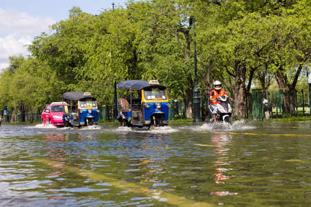 BANGKOK THAILAND - OCTOBER 29 : Tuk-tuk taxi in deep water during the monsoon flooding at Sanam Luang on October 29, 2011 in Bangkok, Thailand.のeditorial素材