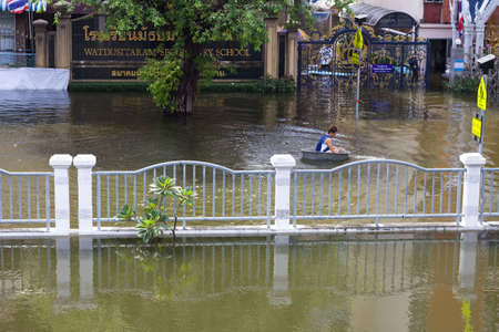BANGKOK, THAILAND - OCTOBER 30 : An unidentified man uses a enameled bowl as a boat during the worst flooding in decades on October 30,2011  Bangkok, Thailand.のeditorial素材