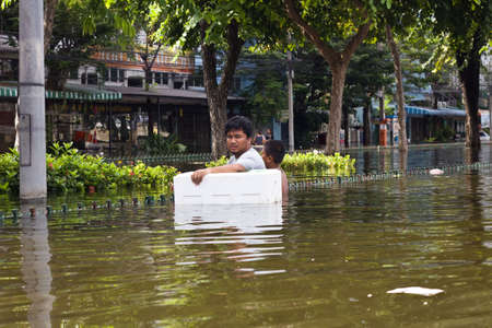 BANGKOK, THAILAND - OCTOBER 30 :  An unidentified man wading through the flood after the monsoon rain on October 30,2011  Bangkok, Thailand.のeditorial素材