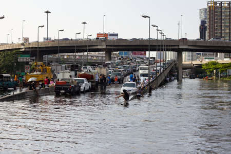 BANGKOK, THAILAND - OCTOBER 30 : Heavy flooding from monsoon rain in Ayutthaya and north Thailand arriving in Bangkok on October 30,2011  Bangkok, Thailand. People Bringing car park on the brigdeのeditorial素材