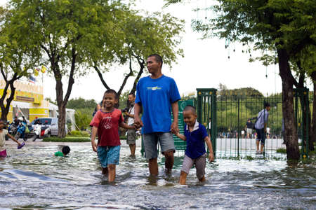 BANGKOK, THAILAND - OCTOBER 30 : An unidentified people walking through the flood after the monsoon rain at Sanam Luang on October 30,2011  Bangkok, Thailand.のeditorial素材