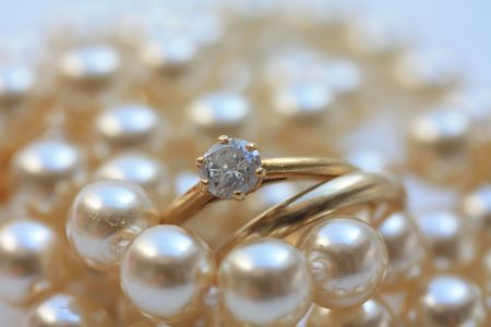Wedding band and engagement ring on pearlsの写真素材