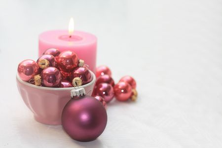 Pink christmas decorations and pink candle on white backgroundの写真素材