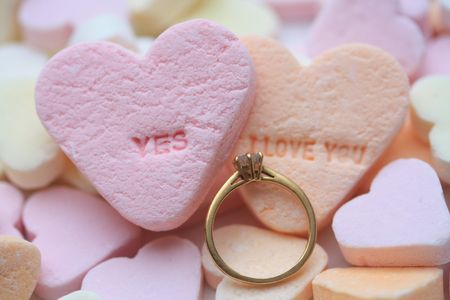 Solitaire diamond engagement ring on valentine candy heart with yes I love you textの写真素材
