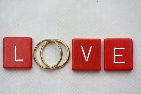 Red wooden letters with simple plain wedding bands.の写真素材