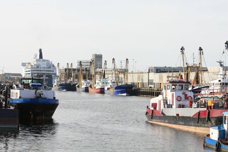Fish trawlers and other boats in a harborの写真素材