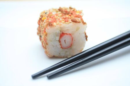 A piece of seame seed sushi and a pair of chopsticksの写真素材