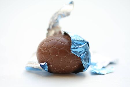 A chocolate easter egg in blue wrapping, close upの写真素材
