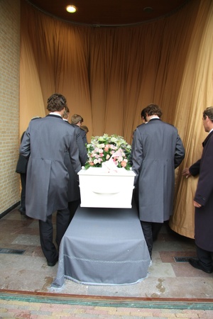 Funeral home employees preparing a casket for a funeral serviceの写真素材
