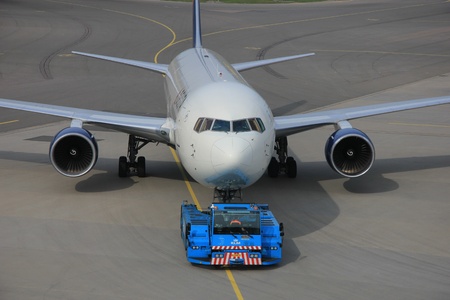 March, 24th, Amsterdam Schiphol Airport the Netherlands: a plane is being pushed back by a tug to avoid jet blastのeditorial素材