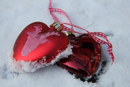 White and red heart shaped ornaments in fresh fallen snow