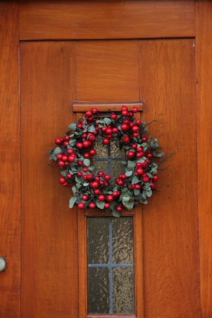 Christmas wreath with berries on a wooden doorの写真素材