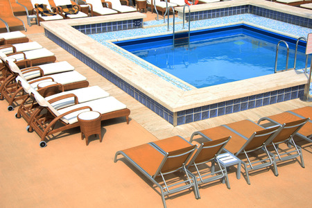 Swimming pool area at a cruise ship with bar and lounge area
