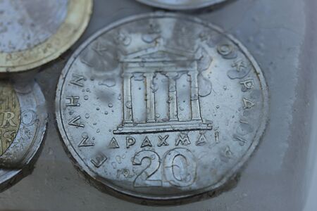 Frozen Assets: Greek euro and Drachme coins in iceの写真素材