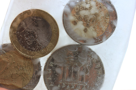 Frozen Assets: Greek euro and Drachme coins in iceの写真素材