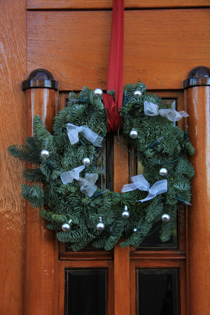 Classic christmas wreath with decorations on a doorの写真素材