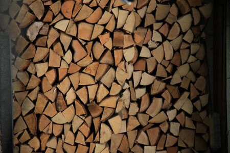 chopped firewood logs stacked up on top of each other in a pile