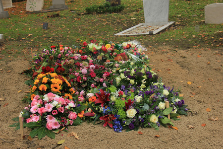 Fresh flowers on a grave after a funeralの写真素材