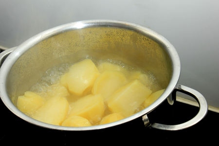 Boiling potatoes in a pan in hot waterの写真素材