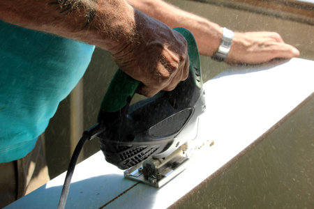 Carpenter working with electric jigsaw or fretsaw