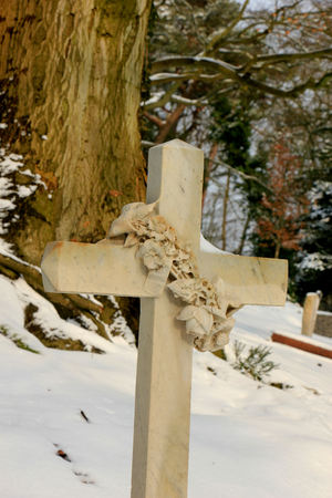 a cross grave ornament in the snowの写真素材