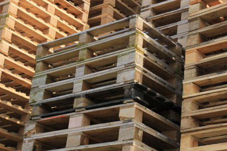 Stacked wooden pallets at a pallet storageの写真素材