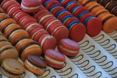 Macarons in various flavors and colors on display in a storeの写真素材