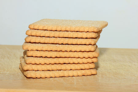 Stacked plain bisuits on a wooden cutting board