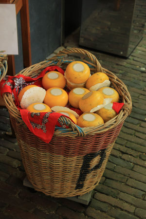 Traditional Dutch cheeses on display in a wicker basketの写真素材