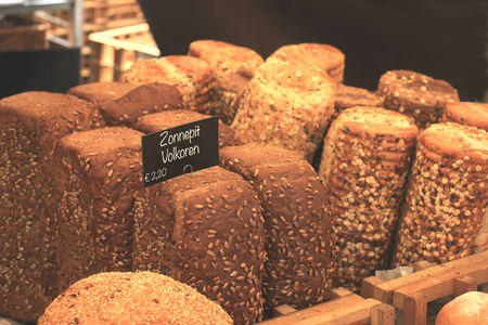 Luxury artisanal bread at a market (text on tags: product and price information in Dutch)の写真素材