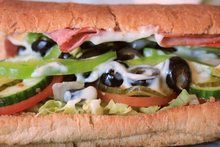 Fresh made whole grain sandwich with lettuce, cold cuts, vegetables and cheeseの写真素材