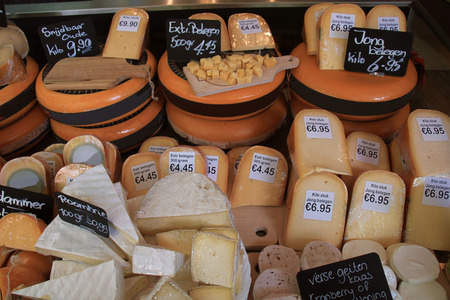 Traditional Dutch cheeses on display in a store (text on labels: price and product information in Dutch, old cheese and medium "matured")の写真素材