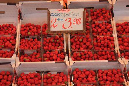 Strawberries in small containers on a market stall (text on tag: Dutch product informationL Strawberries, 2 boxes for  3.98)のeditorial素材