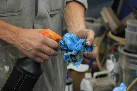 Man polishing a car, putting spray on a ragの写真素材