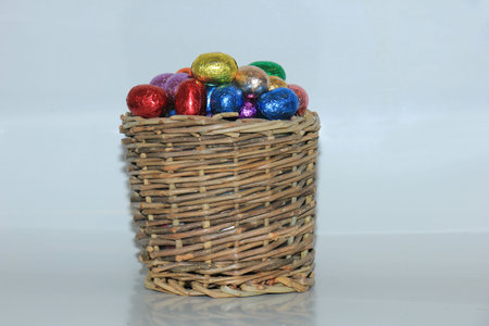 Foil wrapped chocolate easter eggs in a wicker basket