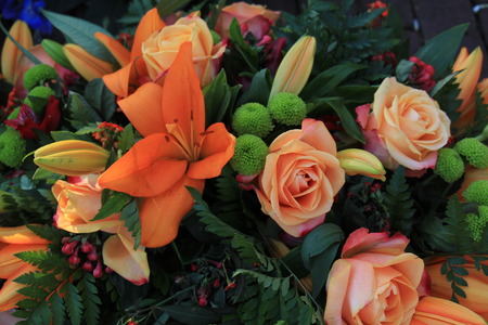 Mixed orange flower arrangement for a wedding: lilies and rosesの写真素材