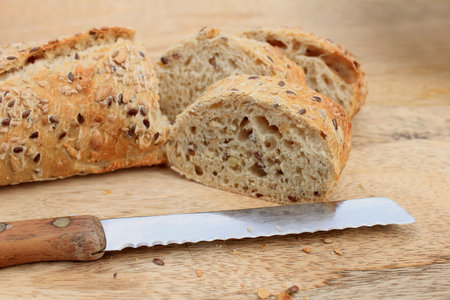 Fresh wholegrain baguette on a wooden cutboard