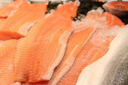 Fresh salmon on ice at a fish marketの写真素材