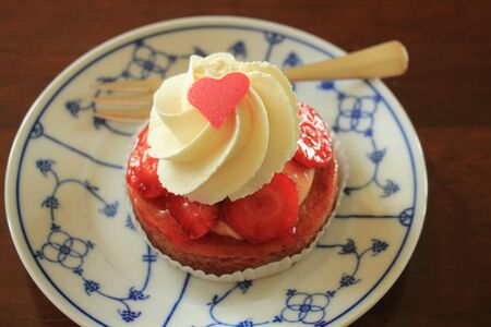Fresh strawberry confectionery with whipped cream and heart decoration