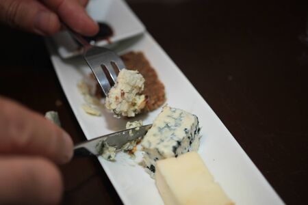 Man eating French cheese served as a dessert with bread and syrup