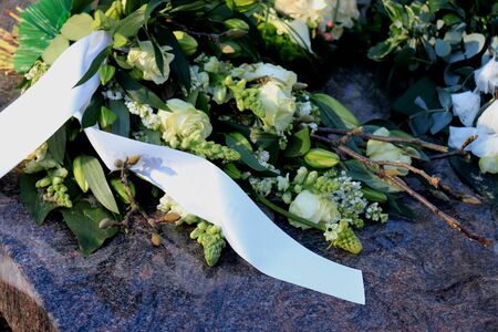 Sympathy flowers with satin ribbons on a graveの写真素材