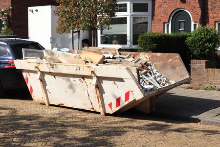 Loaded dumpster or disposal bin near a construction site