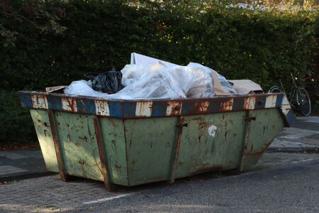 Loaded dumpster or disposal bin near a construction siteの写真素材