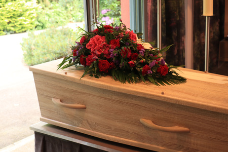 A coffin with a flower arrangement in a morgue, a funeral service