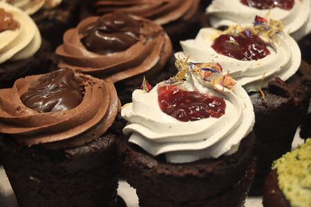 Fresh made chocolate cupcakes on display in a shop windowの写真素材
