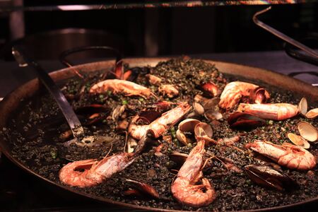 Arros negre or black paella, a traditional Catalan seafood dish with gambas and musselsの写真素材